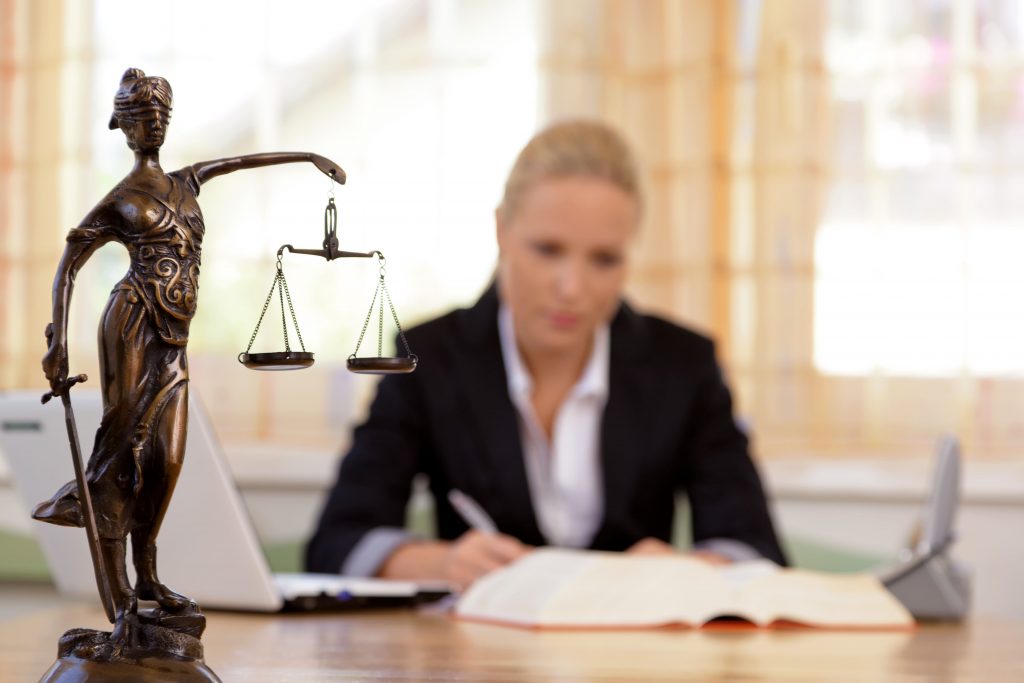 Woman lawyer sitting at desk working on legal case.