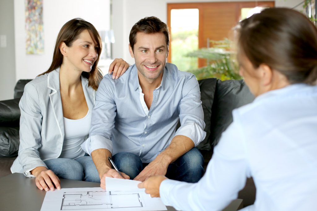 Home buyer couple sitting with real estate lawyer